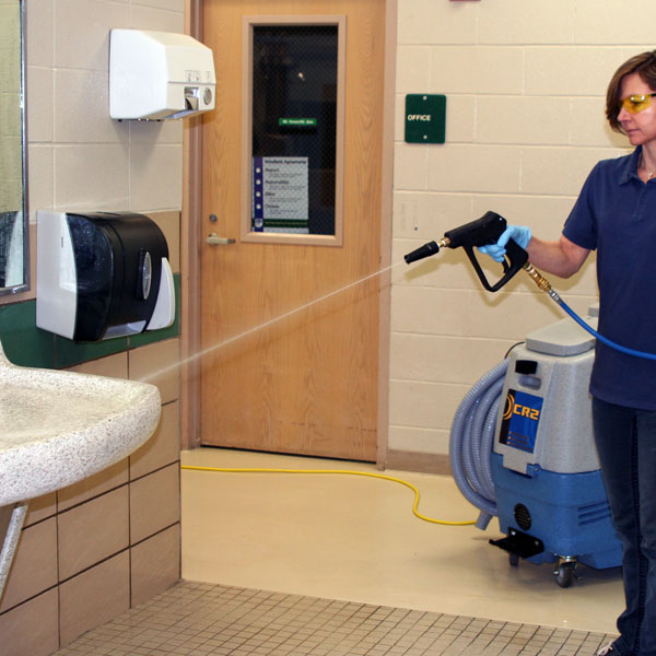 Women cleaning bathroom with high pressure spray gun.