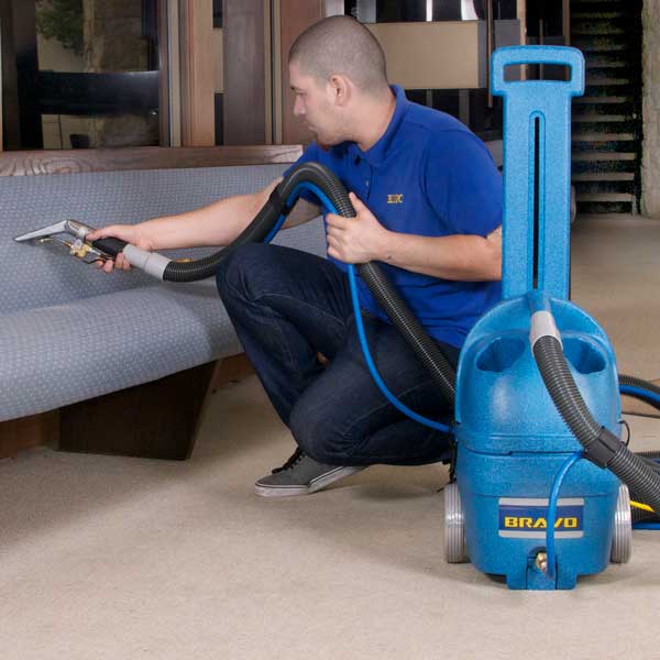 Man cleaning furniture upholstery with Bravo Heated Automotive 3 Gallon Spotter Extractor.